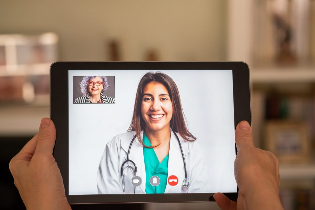 elderly woman having video call consultation with doctor on tablet I StrongLink Technology