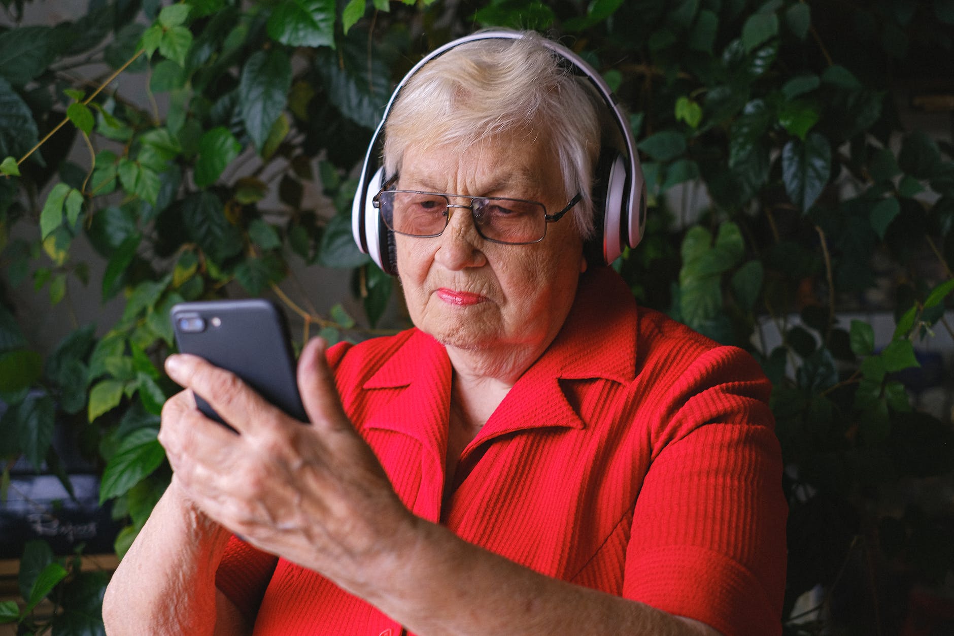 aged woman using smartphone while listening to song I StrongLink technology