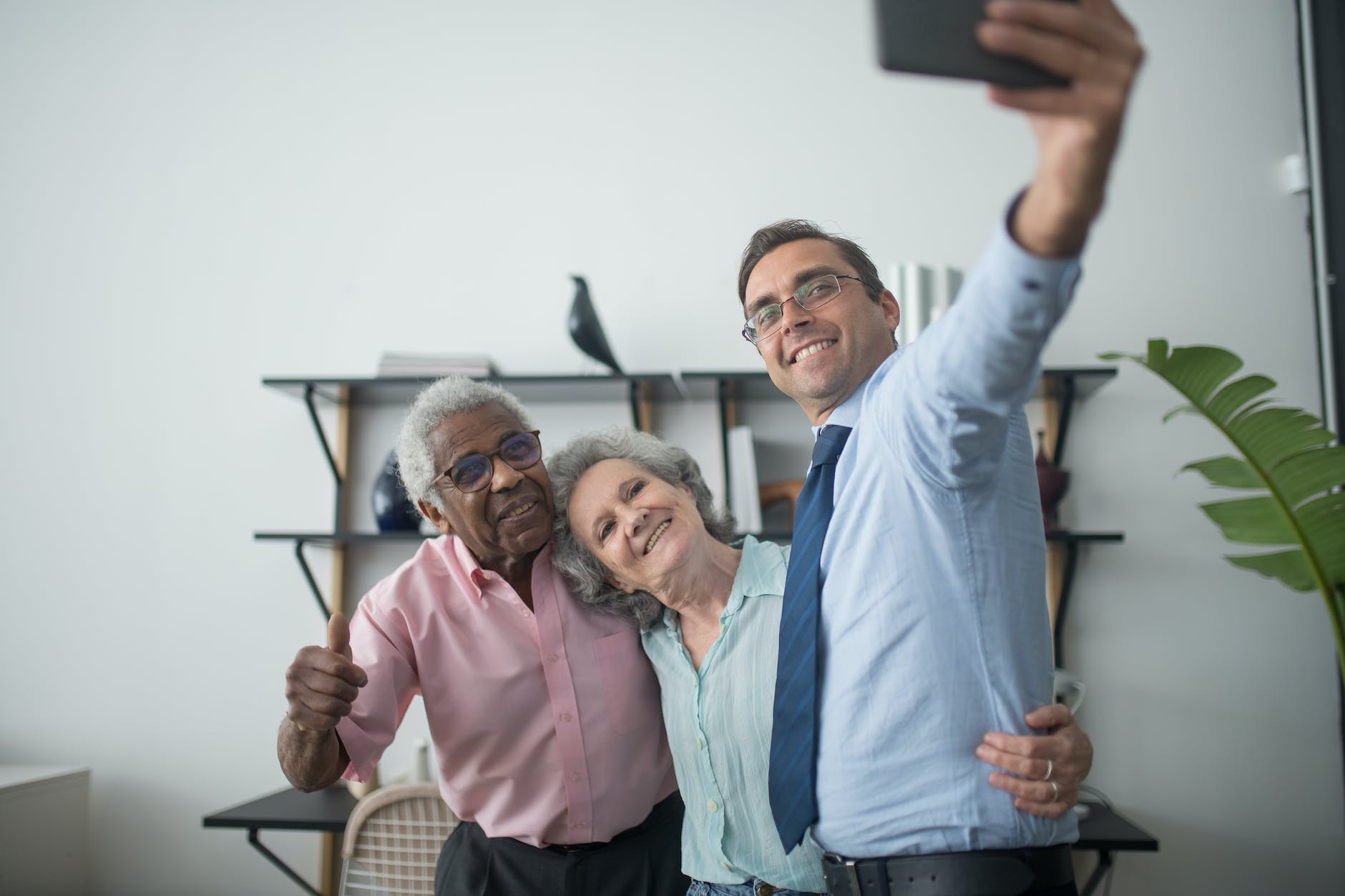 man holding a cellphone taking group selfie I StrongLink Technology Introduces Smartphone Basics with CenterWell Senior Primary Care